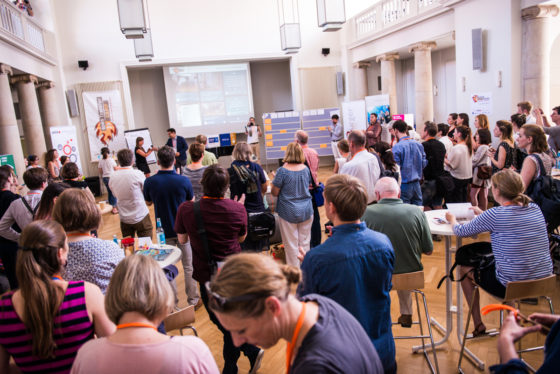 Mehrere Dutzend Menschen stehen in einem Saal.