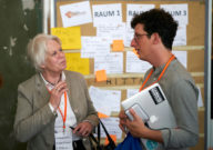 Ein junger Mann spricht mit einer älteren Frau.