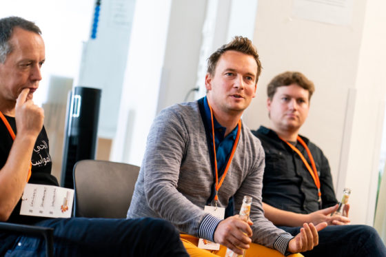 Ein Mann sitzt in einem Stuhlkreis und spricht.