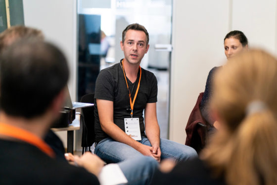 Ein Mann sitzt im Stuhlkreis und erzählt.