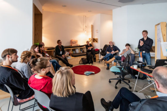 Mehrere Menschen sitzen in einem Kreis zusammen.