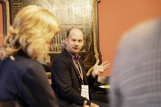 Ein Mann spricht, zwei Menschen hören zu.