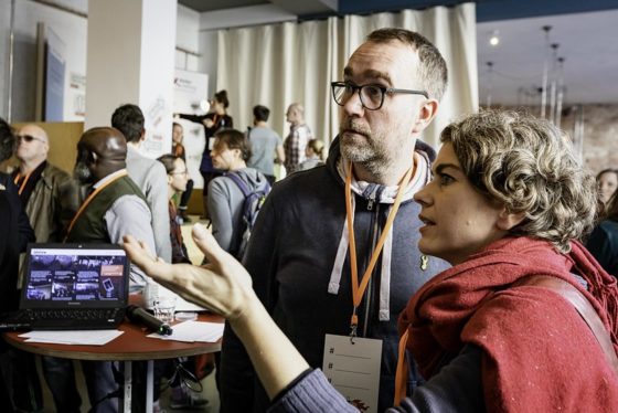 Ein Mann und eine Frau stehen in einem Raum voller Menschen.